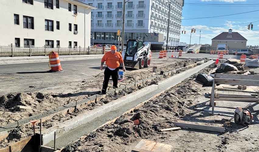 Curbside concrete gutter repair by construction crew in New York City