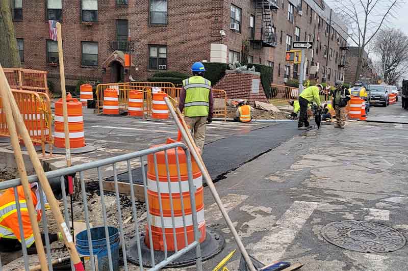 NYC asphalt paving crew resurfacing a busy commercial street